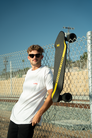 Guy hanging out with his electric shortboard on a sunny day